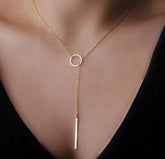 This product appears to be a minimal gold-plated lariat necklace featuring a circle and a vertical bar