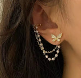 These earrings are described as Butterfly Pearl Earcuff Tassel Earrings, featuring a rhinestone-adorned butterfly stud connected to a cascading pearl chain ear cuff.