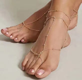 a pair of silver-toned beach barefoot sandals with faux pearls.