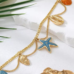 This is a gold-toned, multi-layer women's anklet featuring starfish and shell charms.