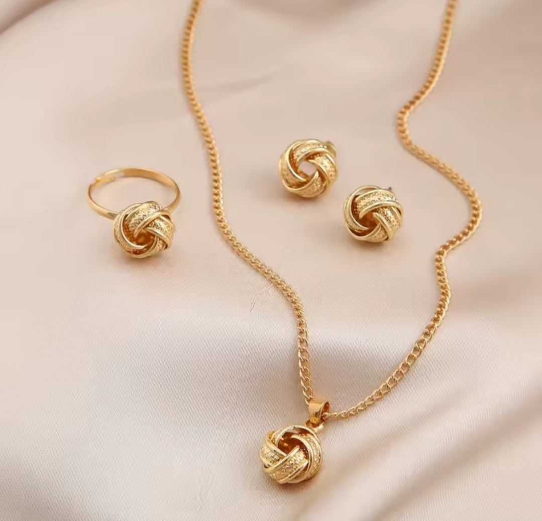 a gold-color metal jewelry set featuring a twisted knot design, typically consisting of a necklace, earrings, and a ring.