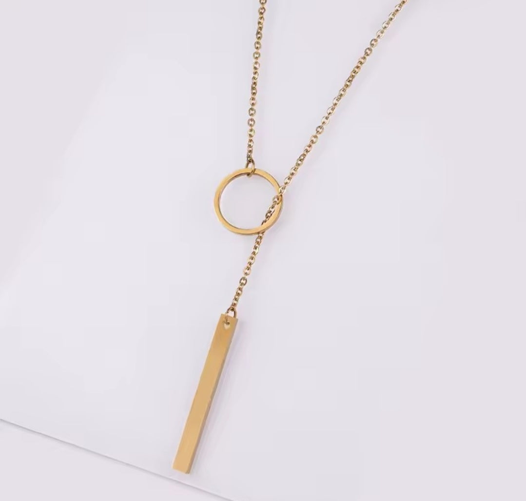 This product appears to be a minimal gold-plated lariat necklace featuring a circle and a vertical bar 