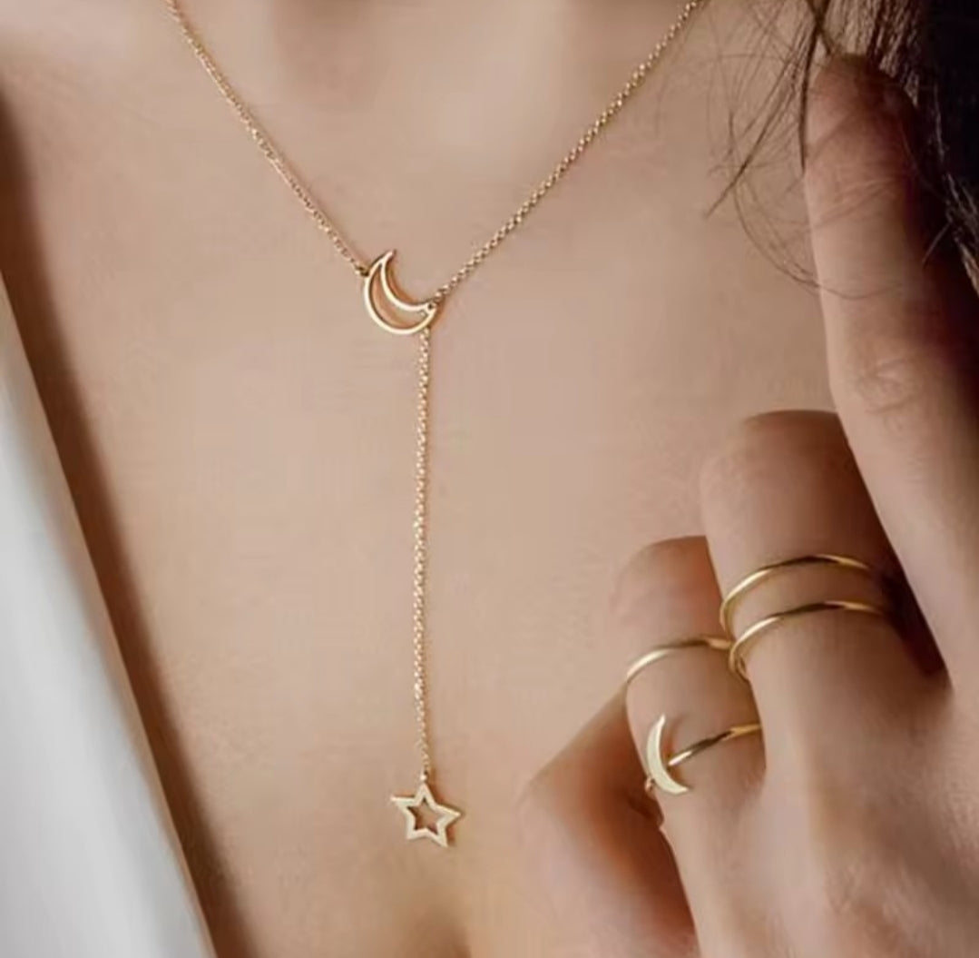 a gold-toned lariat necklace featuring a crescent moon pendant and a star charm, similar to styles from Larancie or Jewels Galaxy.