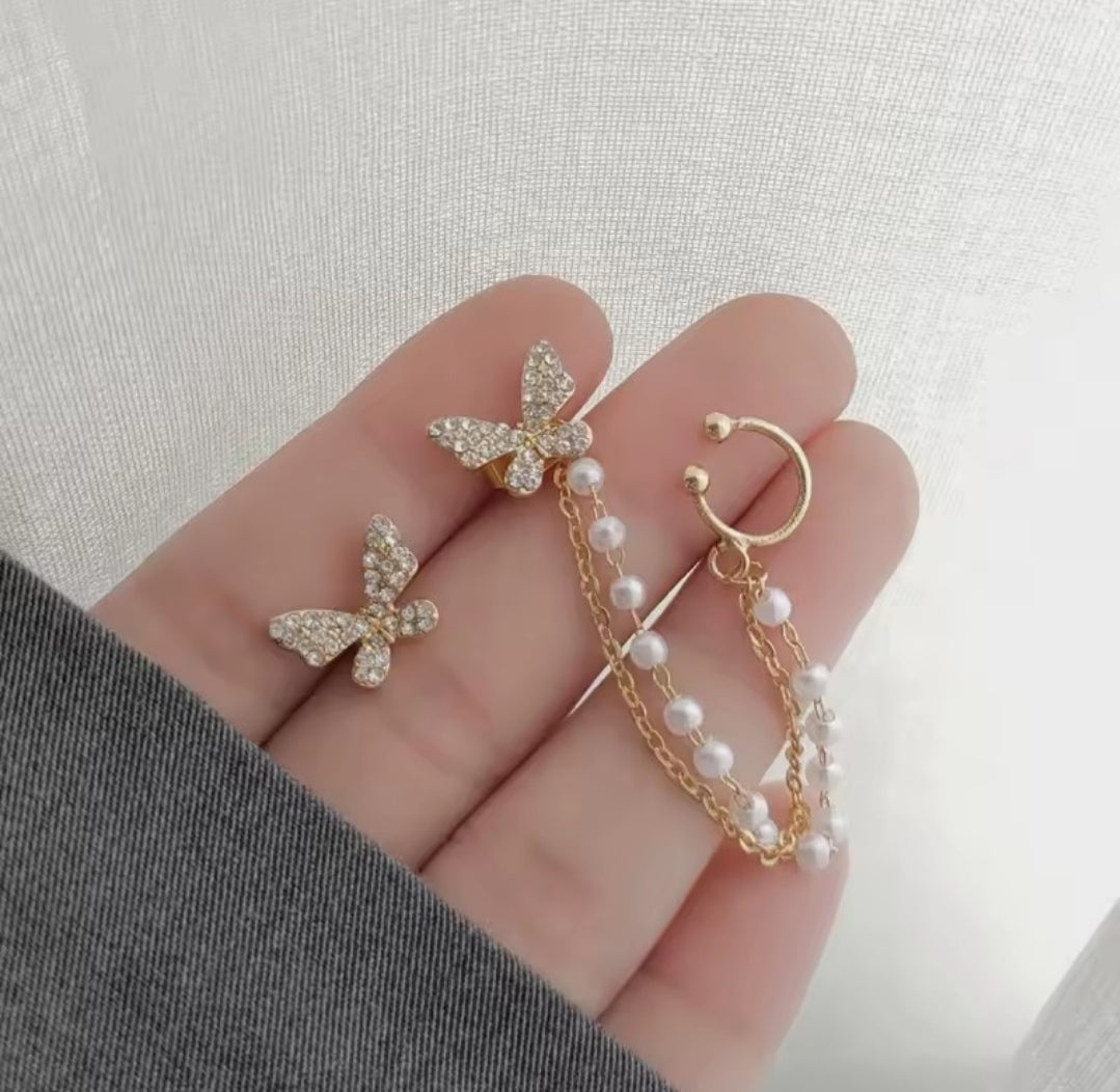 These earrings are described as Butterfly Pearl Earcuff Tassel Earrings, featuring a rhinestone-adorned butterfly stud connected to a cascading pearl chain ear cuff. 