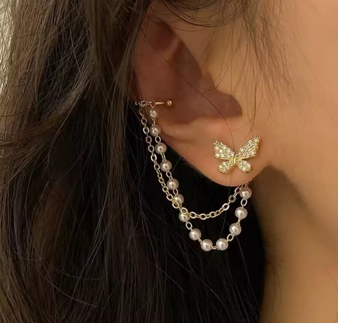 These earrings are described as Butterfly Pearl Earcuff Tassel Earrings, featuring a rhinestone-adorned butterfly stud connected to a cascading pearl chain ear cuff. 