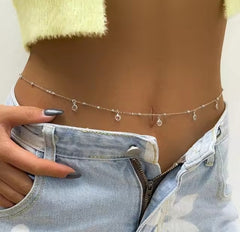 a gold-toned belly waist chain featuring delicate charms and circular accents.