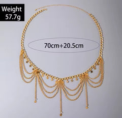 a gold-colored, multi-layered metal belly chain with small ball or coin pendants. 